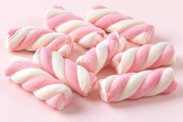 Marshmallow Twists. Marshmallow twists, soft ropes of pink and white marshmallow twisted together in a spiral, matt, fluffy and lightly dusted.